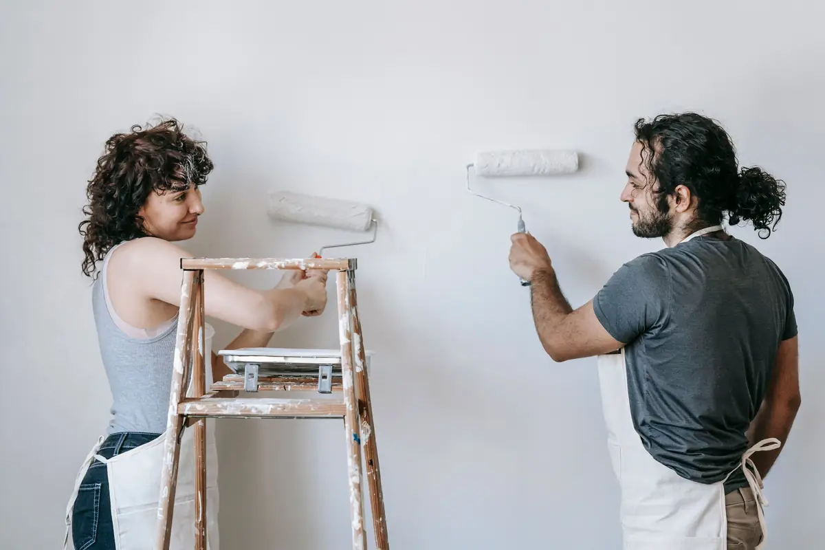 People painting a wall together — painting help in Syracuse